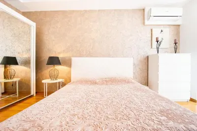 a bedroom with a large bed and two lamps at Apt 