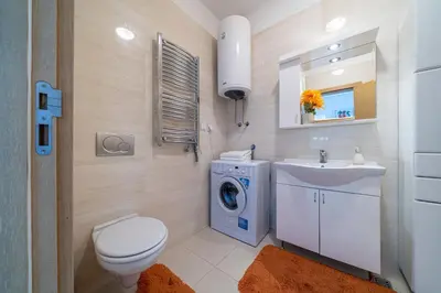 a bathroom with a toilet sink and a washing machine at Apt 