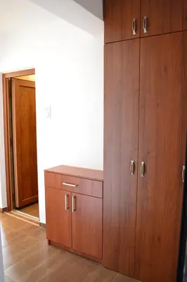 a large wooden cabinet in a room with a mirror at Apartment Matea in Petrovac na Moru