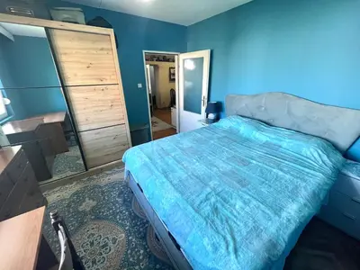 a blue bedroom with a bed and a dresser at Albatros Apartments in Bar