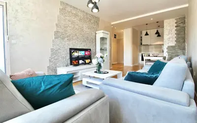 a living room with two blue couches and a tv at Albatros Apartments in Bar