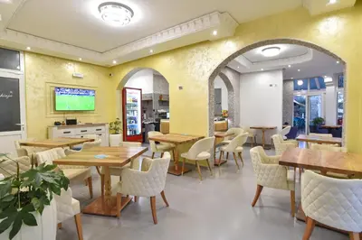 a dining room with wooden tables and chairs at Hotel Galeb in Čanj