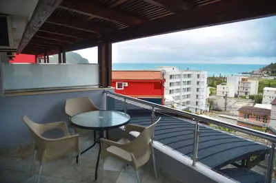a balcony with a table and chairs and the ocean at Hotel Galeb in Čanj