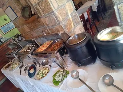 a table with some food and pots and pans of food at Hotel Galeb in Čanj