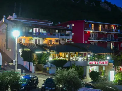 a hotel with a parking lot in front of a building at Hotel Galeb in Čanj