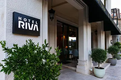 a hotel riya sign on the side of a building at Hotel Riva by Aycon in Petrovac na Moru
