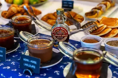 a table topped with cups of tea and a bottle of alcohol at Hotel Riva by Aycon in Petrovac na Moru