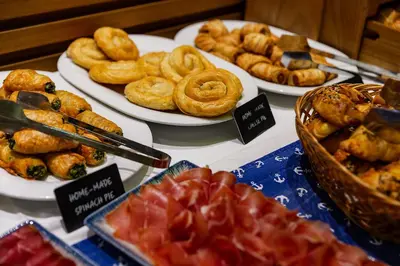 a display of different types of pastries and other foods at Hotel Riva by Aycon in Petrovac na Moru