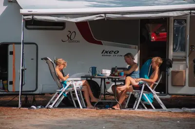 two women sitting at a table in front of a rv at MCM Camping in Ulcinj