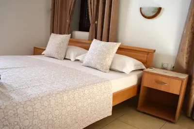 a bedroom with a bed with white sheets and pillows at Villa Marinero in Ulcinj