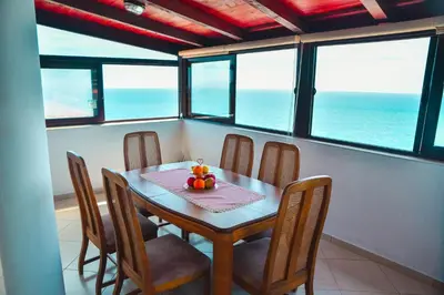 a dining room with a table and chairs and the ocean at Villa Marinero in Ulcinj