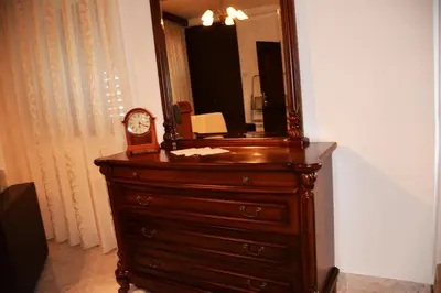 a dresser with a mirror and a clock on it at Villa Marinero in Ulcinj