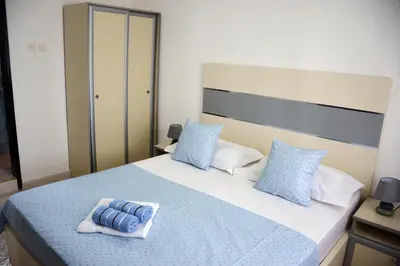 a bedroom with a large bed with blue and white pillows at Villa Marinero in Ulcinj