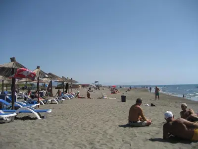 a group of people sitting on the beach at Guest House Vila Mimoza in Ulcinj