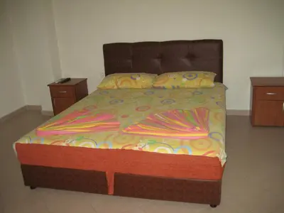 a bed in a room with two nightstands and a bed with avertisement at Guest House Vila Mimoza in Ulcinj