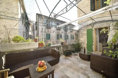 an outdoor patio with a bunch of fruit on a table at Palazzo Max and Alex Apartments in Kotor