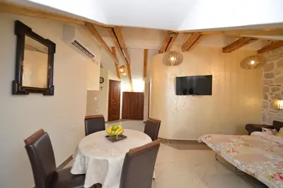 a dining room with a table and a television at Palazzo Max and Alex Apartments in Kotor