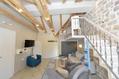 a living room with a couch and a staircase at Palazzo Max and Alex Apartments in Kotor