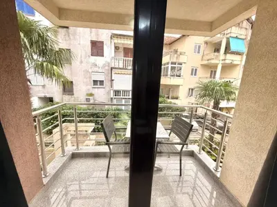 a balcony with two chairs and a view of a building at Apartments Villa Stefan in Budva
