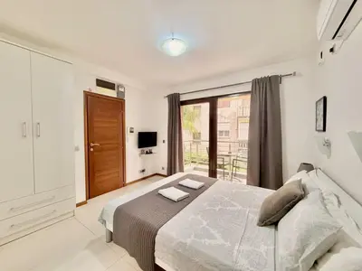 a bedroom with a bed and a large window at Apartments Villa Stefan in Budva