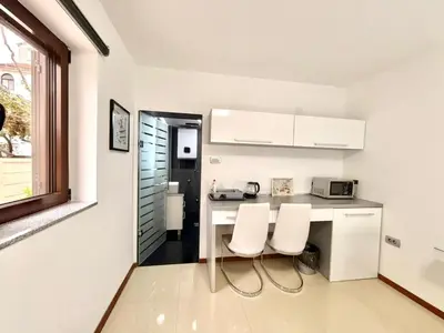 a kitchen with two white chairs and a counter at Apartments Villa Stefan in Budva