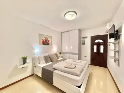 a white bedroom with a large white bed in it at Apartments Villa Stefan in Budva