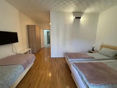 a room with two beds and a flat screen tv at Apartments Mitende in Budva