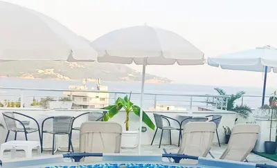 a patio with chairs and tables and umbrellas at Apartments Mitende in Budva