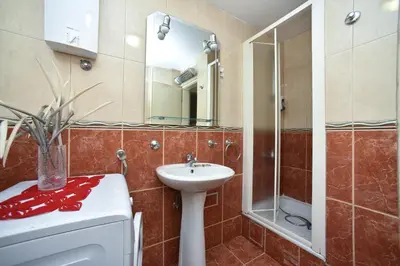 a bathroom with a sink and a toilet and a mirror at Bologna Apartments in Budva