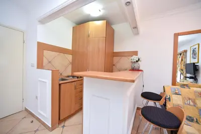 a kitchen with a counter and some chairs in a room at Bologna Apartments in Budva