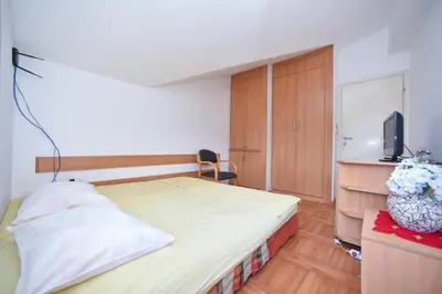 a bedroom with a bed and a tv on a cabinet at Bologna Apartments in Budva