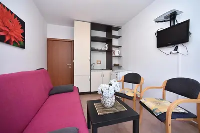 a living room with a purple couch and a table at Bologna Apartments in Budva