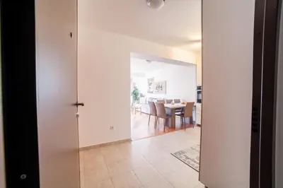 a kitchen and dining room with white walls and a table at Apartman Marija in Budva