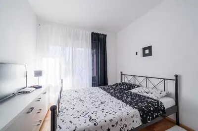 a bedroom with a black and white bed and a desk at Apartman Marija in Budva