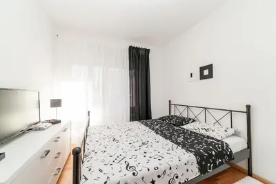 a bedroom with a bed and a desk with a television at Apartman Marija in Budva