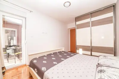 a bedroom with a bed and a large window at Apartman Marija in Budva