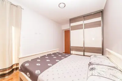 a bedroom with a bed and a large window at Apartman Marija in Budva