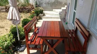a wooden table and two chairs and an umbrella at Apartments 3ADE in Ulcinj
