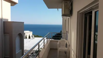 a balcony with a chair and a view of the ocean at Apartments 3ADE in Ulcinj