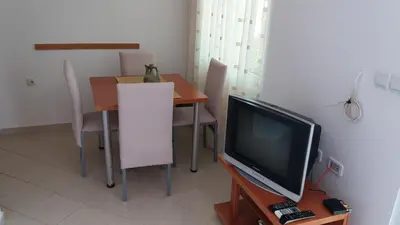 a dining room with a table and a television at Apartments 3ADE in Ulcinj