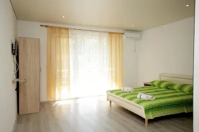 a bedroom with a green bed and a large window at Apartments Victoria in Sutomore