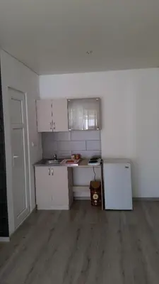 a kitchen with white cabinets and a white refrigerator at Apartments Victoria in Sutomore