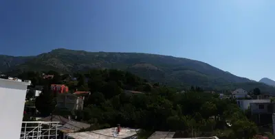 a view of a mountain with trees and houses at Apartments Victoria in Sutomore