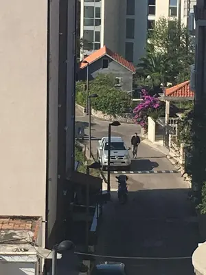 a man walking a bike down a street with a car at Apartments and Rooms Villa Gaga 3 in Budva