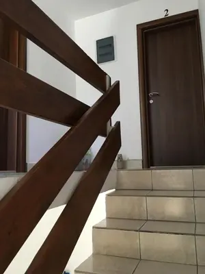 a stairway with a wooden door and a stair case at Apartments and Rooms Villa Gaga 3 in Budva