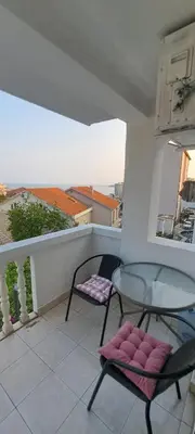 a balcony with a glass table and two chairs at Apartments and Rooms Villa Gaga 3 in Budva
