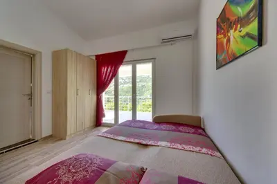 a bedroom with a bed and a large window at Yokana Villa & Pool in Virpazar