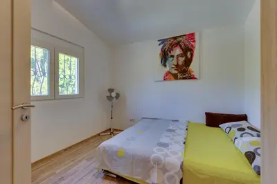 a bedroom with a bed and a painting on the wall at Yokana Villa & Pool in Virpazar
