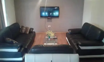 a living room with two leather couches and a tv at Buljarica Bay Apartments in Petrovac na Moru