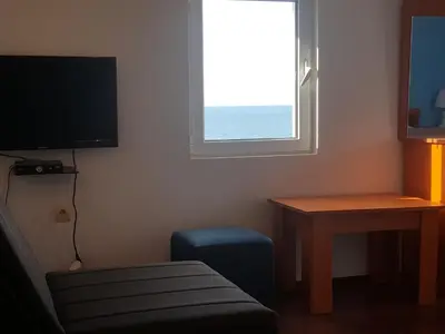 a room with a tv and a table and a window at Buljarica Bay Apartments in Petrovac na Moru